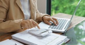 A young woman analyzing financial data and calculating investment returns, representing strategic planning for alternative investments and year-end decisions.
